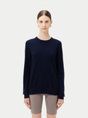 Person wearing a navy sweater and beige shorts on a white background. #color_navy-blue