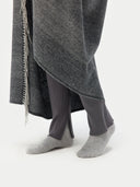 Person wearing a gray coat, dark pants, and gray socks on a white background. #color_steel-silver