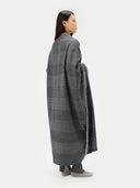 Person wearing a long, dark gray plaid coat on a white background. #color_steel-silver