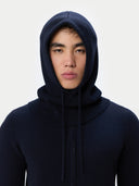 Person wearing a navy blue hoodie against a white background
