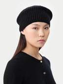 Woman wearing a black knit beret against a white background