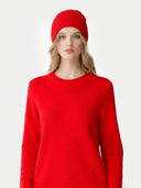 Woman wearing a red sweater and matching red beanie on a white background #color_hibiscus