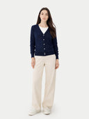 Woman wearing a navy cardigan and beige pants on a white background #color_beige
