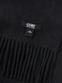 Close-up of a black knit garment with a visible GOBI brand label and ribbed texture. #color_black