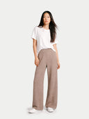 Woman wearing a white t-shirt and brown pants on a white background. #color_taupe #ai-image