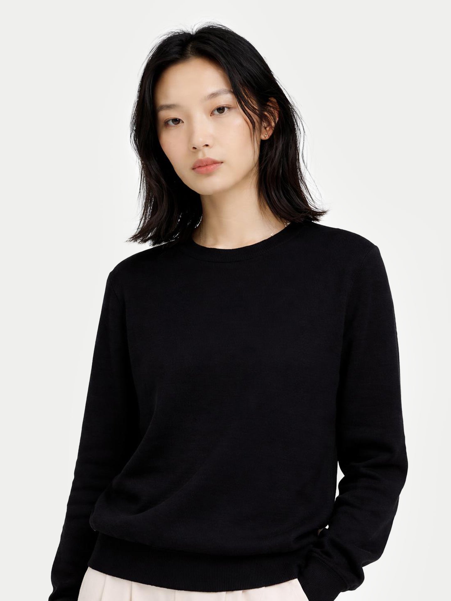 Person wearing a black sweater on a white background