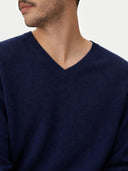 Navy blue sweater worn by a person on a light gray background