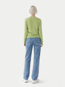 back view of a woman wearing a green sweater and blue jeans on a white background. #color_jade-green