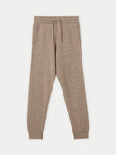 A pair of beige cashmere kids track trousers with an elastic waistband and ribbed cuffs. #color_taupe