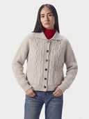 Model wearing the Natural Beige cashmere cutaway-collar cable-knit cardigan with pointelle cables and patch pockets, front view