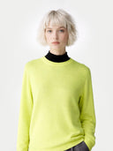 Person wearing a bright yellow sweater over a black turtleneck on a white background #color_lime-yellow
