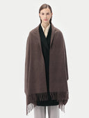 Woman wearing a brown scarf with fringes on a white background