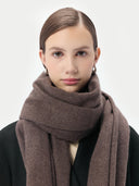 Woman wearing a brown scarf against a white background