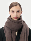 Woman wearing a brown scarf against a white background #color_brown