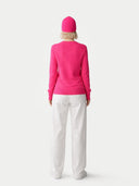 Person wearing a bright pink outfit with a matching hat on a white background