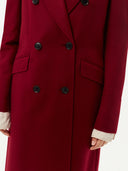 Red coat with black buttons on a white background. #color_bordeaux