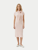 Shop GOBI Cashmere dresses — woman in a pale pink knit cashmere midi dress with tie-neck detail
