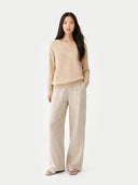 Woman wearing a beige sweater and pants on a white background #color_Beige