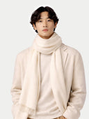 Person wearing a beige scarf and coat on a white background. #color_off-white #ai-image