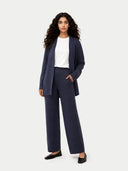 Woman wearing a navy suit with a white shirt on a white background. #color_soft-indigo #ai-image