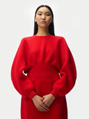 Person wearing a red sweater against a white background