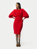 Woman wearing a red dress with puff sleeves on a white background #color_fiery-red