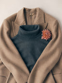 Blue cashmere long-sleeve polo shirt with a GOBI collar label and two notebooks tucked under the sleeve