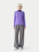 Person wearing a purple sweater and gray pants on a white background #color_dusted-peri