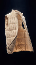 A cream CashmereTech reversible quilted vest on a dark background