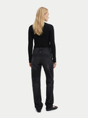 Person wearing black jeans and a black top on a white background