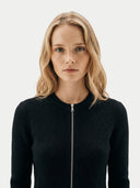 Woman wearing a black ribbed knit sweater with a zipper on a white background