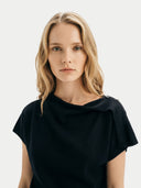 Woman wearing a black top against a white background