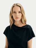 Woman wearing a black top against a white background