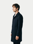 side view of a man wearing a black coat against a white background. #color_black #ai-image