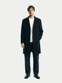 Man wearing a dark coat over a white shirt on a plain background. #color_black #ai-image