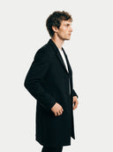 side view of a man wearing a black coat against a white background. #color_black #ai-image
