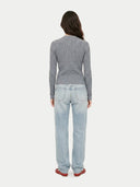 Person wearing a grey jumper and light blue jeans on a white background #color_steel-gray