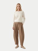 Woman wearing a cream sweater and beige pants on a white background. #color_dark-brown #ai-image