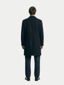 back view of a man wearing a black coat from behind on a white background. #color_black #ai-image