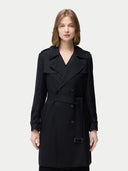 A woman wearing a double-breasted black cashmere trench coat with a belt and notched lapels. #color_black