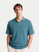 Man wearing a teal polo shirt against a white background #color_mineral-green