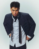 A man in a navy quilted CashmereTech jacket over a white shirt and tie