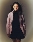A woman in a pink CashmereTech puffer jacket over a black dress