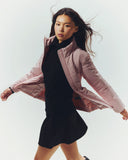A woman in a pink CashmereTech puffer jacket mid-stride