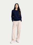 Person wearing a navy sweater and beige pants on a white background. #color_dark-indigo #ai-image