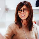 Simona Spaggiari smiling in round glasses and a beige cashmere sweater