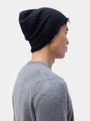 Person wearing a black beanie and gray shirt against a white background