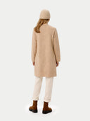 back view of a woman wearing a beige coat, beanie, and boots on a white background. #color_beige #ai-image