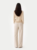 Woman wearing a beige sweater and cream pants on a white background #color_Beige
