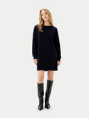 Woman wearing a black dress and black boots on a white background. #color_navy #ai-image